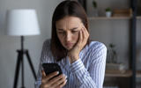 Frowning woman checks phone