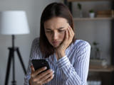 Frowning woman checks phone