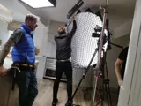Photograph of videographers adjusting light