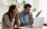 Confused couple looking at a laptop