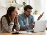 Confused couple looking at a laptop
