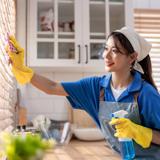 A woman wiping window blinds.
