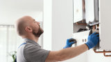 A gas engineer working on a boiler