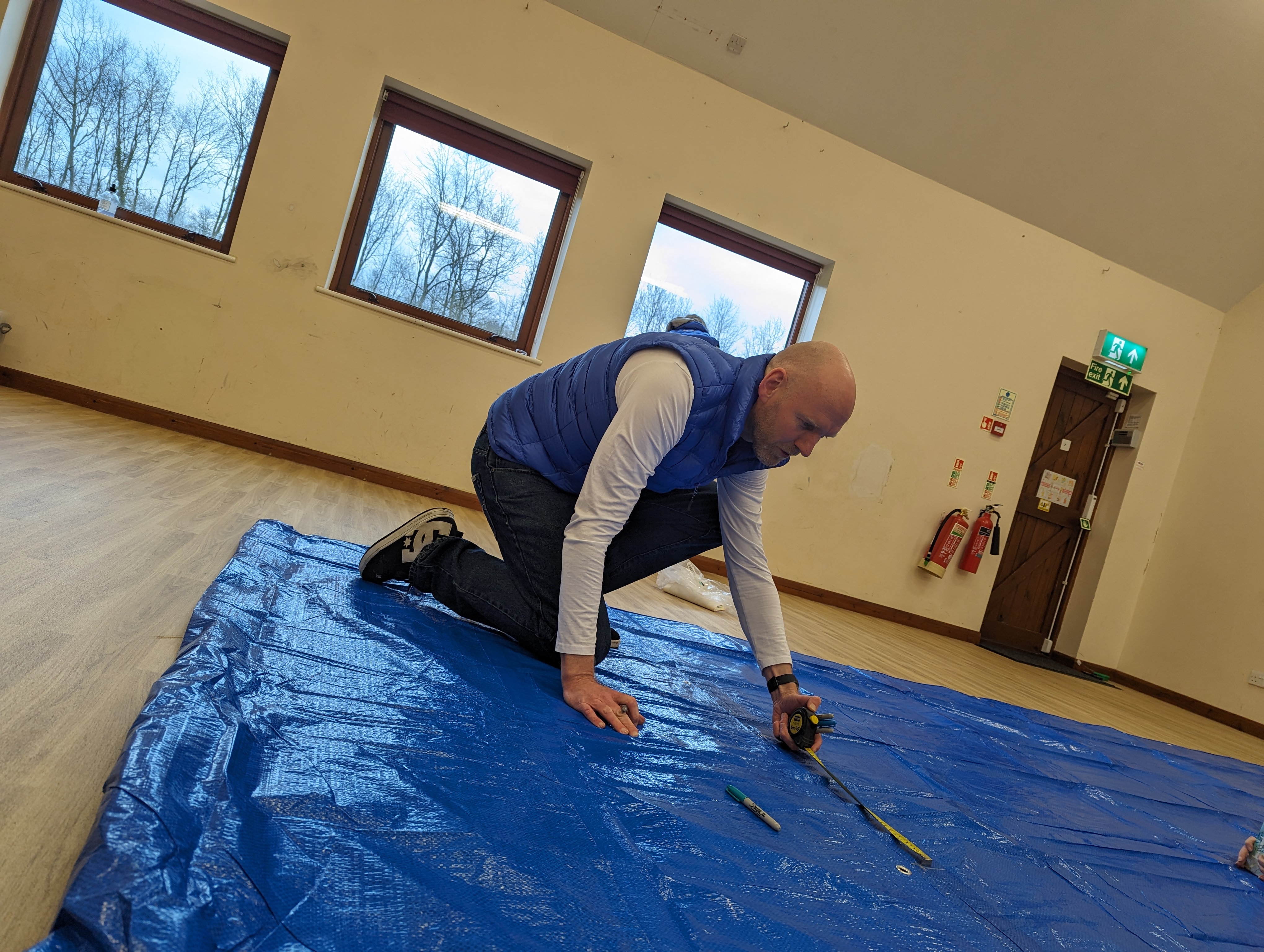 Iain marks up blue tarpaulin
