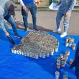 Photograph of cans being arranged into an 'O' shape