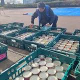 Photograph of people loading cansd