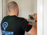 An electrician working on a consumer unit