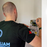 An electrician working on a consumer unit