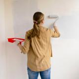 A woman painting a wall.