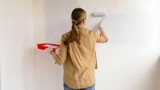 A woman painting a wall.